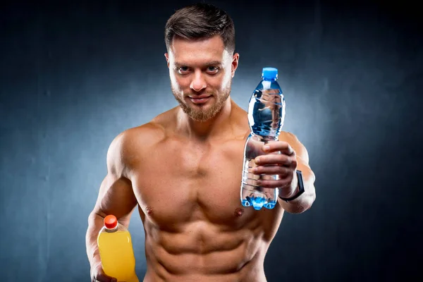 性感的运动员拿着一瓶水和苏打水 在健康饮料和有害饮料之间做出选择 — 图库照片