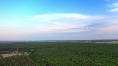 İnsansız hava aracı yazın doğal ortamda yükseliyor. Açık havada açık gökyüzünün altındaki yeşil orman. Kırsal kesimde güzel bir manzara.