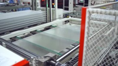 Robot makine içeride güneş paneli yapıyor. Modern bir fabrikada güneş pilleri üretme teknolojisi.