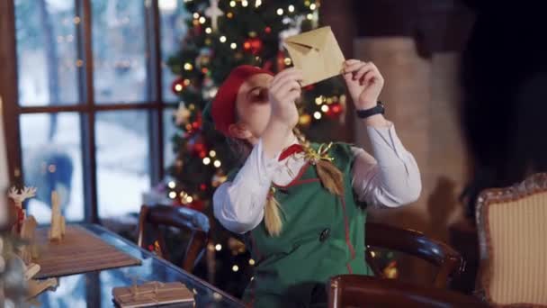 Słodki Elf Kopertą Tle Lampek Świątecznych Szczęśliwa Elf Kobieta Patrząc — Wideo stockowe