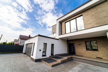 Garajı ve kaldırım taşı yolu olan rahat ve modern bir ev. Modern mimari.