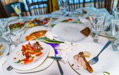 Restoran masasındaki yemekten sonra kirli tabak ve bardakların en üst görüntüsü. Yemekten sonra kirli tabakta kalan yemekler..