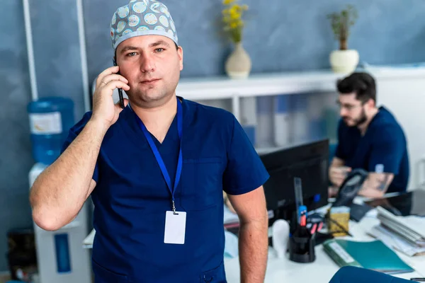 Férfi Orvos Beszél Telefonon Keresztül Doktor Kék Köpenyben Asztali Szögben — Stock Fotó