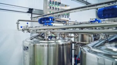 Çağdaş süt imalathanesi. Sütle suyu karıştırmak için kocaman kaseler. Peynir hazırlamak için özel ekipman.