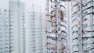 Sağlık hizmeti, görme ve görme konsepti. Optik mağazasında gözlük seçen mutlu kadın. Gözlük dükkanı..