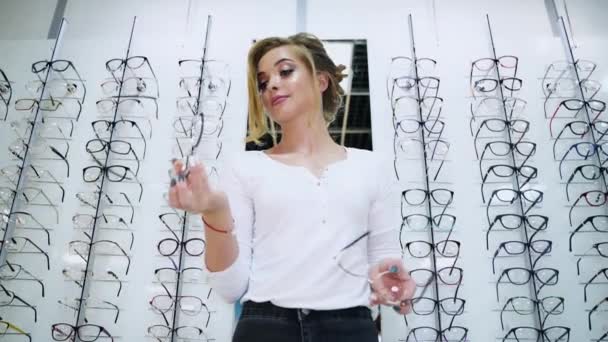 站在光学商店里戴眼镜 女人选眼镜 — 图库视频影像