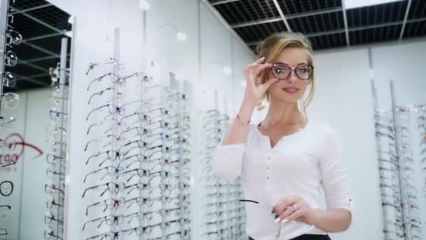 一个戴眼镜的漂亮女人站在光店旁边 眼科学 — 图库视频影像