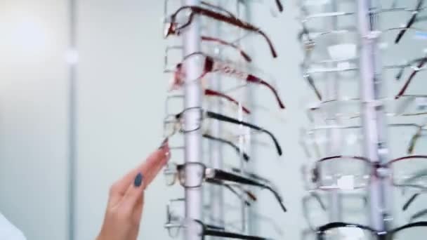 Glasögonaffären Stå Med Glasögon Optikförrådet Kvinnans Hand Väljer Glasögon — Stockvideo