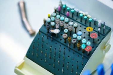 Diş aletleri. Cam levhada kök kanal tedavisi için matkaplar ve iğneler. Resmi kapat.