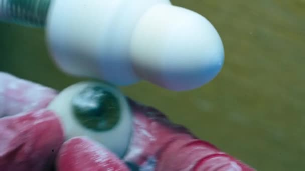 Протез Глаза Полируется Специальным Инструментом Руки Перчатках Держащих Искусственный Пластиковый — стоковое видео