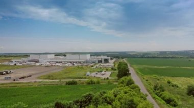 Endüstriyel kompleksin yakınındaki kamyonlar için park yeri. Doğal yeşil arka planda modern üretim bölgesinin yan görünüşü.