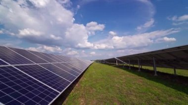 Gündüz vakti modern bir istasyonda güneş paneli. Güneş panelinin üzerinde beyaz bulutlar. Alternatif temiz elektrik. Bir enerji santralinde yenilenebilir enerji yaratmak için yenilikçi bir teknoloji.