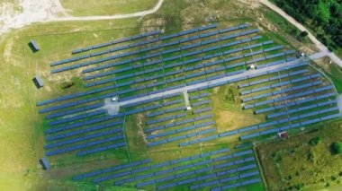 Sahada güneş panelleri var. Yukarıdan kırsal bölgedeki modern yenilenebilir enerji çiftliğine bakın. Hava görüntüsü. Kamera hareket ediyor.