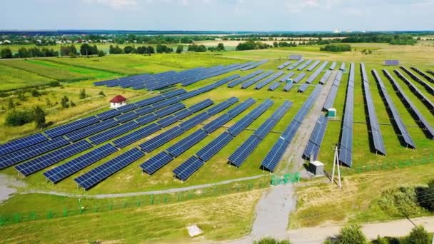 自然景観の中で太陽光発電所 田園地帯のフィールド上の太陽電池パネルの行の空中ビュー — ストック動画