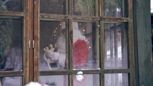 サンタクロースは窓から見ている 雪玉が窓から飛んできた サンタと一緒に家の中に屋外からの眺め クリスマスの時間 — ストック動画
