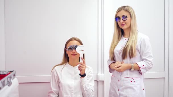 Junge Frau Empfang Einer Schönen Augenärztin Lady Zieht Augentestgerät Für — Stockvideo