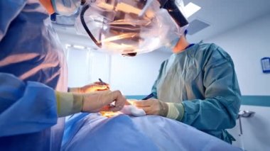 Ameliyathanede modern tıbbi ekipmanlarla ameliyat. Klinikteki ameliyat sırasında doktorların takım çalışması. Yakın plan..