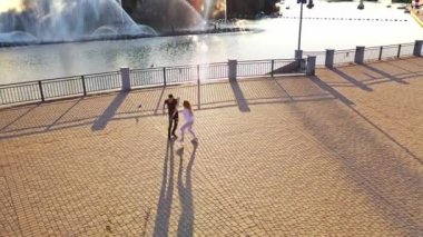 Modern dansçılar sokakta dans ediyor. Şehir yaşam tarzı. Hip-hop nesli. Videodaki kızın ve erkeğin duygusal hareketleri. Kayalık taşlar ve fondü arka planında genç gösterişli bir çift. Hava görüntüsü. Genç güzellik yakışıklı oğlanla dans ediyor.