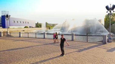 Modern erkek dansçı sokakta dans ediyor. Şehir yaşam tarzı. Hip-hop nesli. Videodaki çocuğun duygusal hareketleri. Kayalık taşlar ve fondü arka planında genç bir adam. Hava görüntüsü. Genç yakışıklı profesyonel dansçı çocuk..