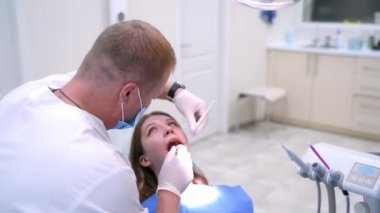 Doktor modern diş kliniğinde hasta dişlerini tedavi ediyor. Sağlık dişleri konsepti. Stomatolojide genç bir kadın..