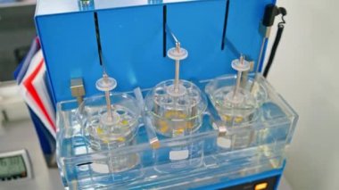 Laboratuvardaki deneyler. Çözünme aparatının kaygan görüntüsü ilaç haplarını test ederek sıvılarda çözünen. Laboratuvar rutini.