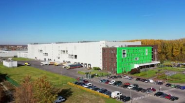 Modern bir bitkinin havadan görünüşü. Büyük bir fabrika ve açık havada arabaları olan bir park yeri. Şehirdeki modern endüstriyel kompleks. Kamera yukarı hareket ediyor.
