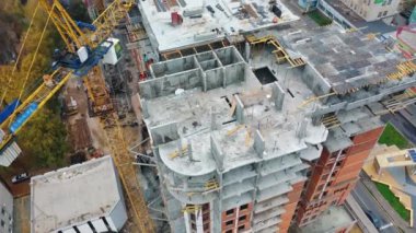 Konut kompleksi inşaatı. Çok katlı bina yapım aşamasında. Vinçler çalışıyor. Hava görüntüsü. Modern blok inşa ediliyor.