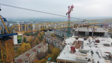Konut kompleksi inşaatı. Çok katlı bina yapım aşamasında. Vinçler çalışıyor. Hava görüntüsü. Modern blok inşa ediliyor.