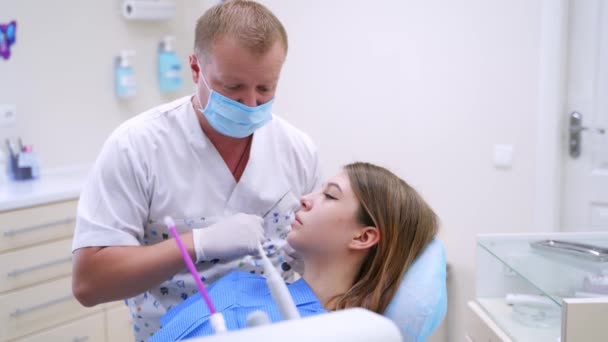 婦人科医の所に来てる マスクで成功した歯科医は 診療所の女性患者に歯を治療します 歯のケアの概念 — ストック動画