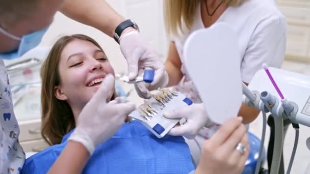 Стоматолог Тримає Штучний Зуб Близько Зубів Пацієнта Стоматолог Помічником Вибирає — стокове відео