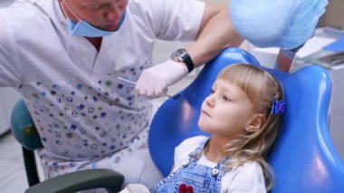 Stomatoloji kürsüsündeki küçük çocuk. Yaklaş. Dişçili kız. Sağlık dişleri konsepti. Modern klinik. Ortodontiste bakın..