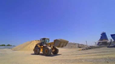 Çağdaş asfalt fabrikası geçmişi. Excavator, asfaltı açık hava tanklarına taşır..
