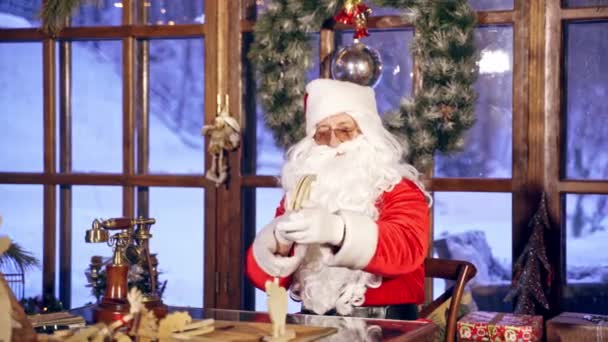 圣诞老人和两只小精灵正在特别装饰的房间里准备迎接圣诞节 女孩精灵正在给一架飞机带来木制礼物 新年和圣诞节的概念 饭来了 — 图库视频影像