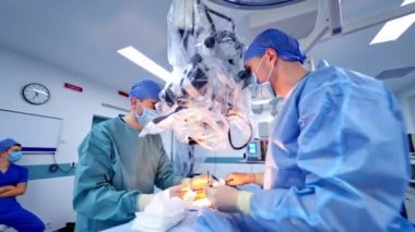 Mikroskop kullanan cerrahların takım çalışması. Tıbbi uzmanlar modern ekipmanlarla bir hastayı ameliyat ediyorlar..