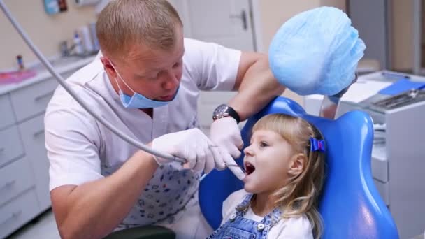 Stomatolog Małą Dziewczynką Dentysta Leczący Zęby Dziecka Gabinecie Dentystycznym Koncepcja — Wideo stockowe