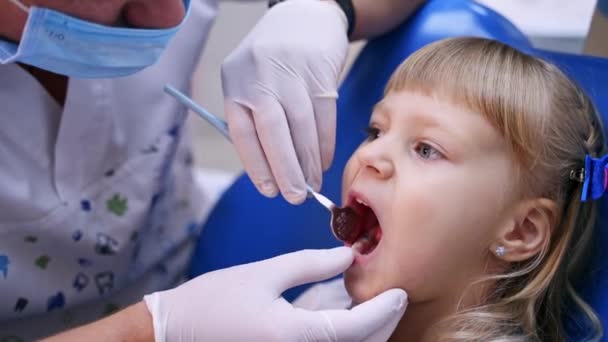의자에 벌리고 보호용 장갑을 아이의 치아를 확인하는 클로즈업 — 비디오