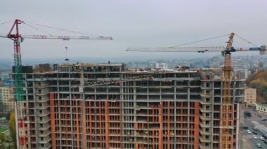 Şehir merkezinde yeni inşaat. Açık havada inşaat halindeki yüksek katlı bina. Hava görüntüsü. Kamera hareket ediyor.
