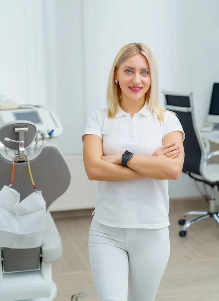 歯科医のオフィスでカメラを見て美しい女性歯科医の肖像画 白い制服を着たストーモロジスト — ストック写真