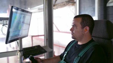 Modern endüstriyel bir fabrikada işçi. İnsanoğlu bir odada oturup monitörlere bakarken robot teknolojilerini yönetiyor..