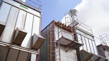 Modern açık hava fabrikası. Mavi gökyüzünün altındaki yeni bir bitkinin devasa endüstriyel arka planı. Kereste fabrikasının dış cephesi..