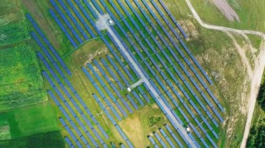 Sahadaki güneş enerjisi panelleri. Güneş enerjisi çiftliğinin en üst hava manzarası. Yenilenebilir yeşil enerji kavramı. Hareket kamerası..