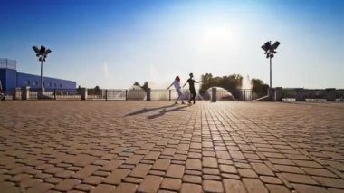 Genç çiftin modern dansı. Kaldırımda dans eden güzel bir çift. Çeşmeye karşı enerjik dans.