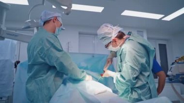 Kök hücre enjeksiyon prosedürü. Cerrah büyük bir şırınga tutuyor ve klinikteki bir hastaya enjekte ediyor. Doktorlar modern klinikte ameliyat yapıyorlar..