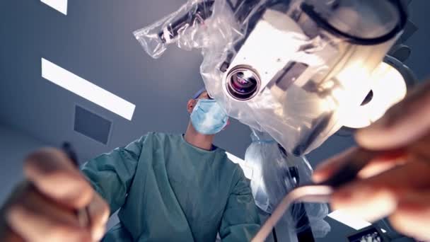 手術中の医療器具を持つ経験豊富な外科医の下からの眺め 健康治療の概念 — ストック動画