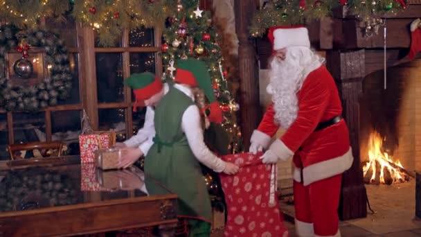 Санта Клаус Ельфами Різдво Два Ельфи Кладуть Подарунки Червону Сумку — стокове відео