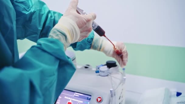 幹細胞注射手順 女性労働者は注射器から特殊な機械に血液を注ぐ 診療所の近代的な設備 — ストック動画