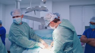 Bir grup doktor bir hastaya ameliyat yapıyor. Ameliyathanede çalışan tıp üniformalı ve maskeli cerrahlar.