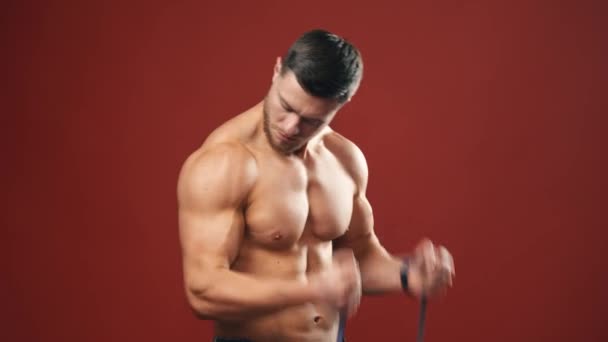 Bíceps Muscular Homem Bonito Fisiculturista Fazendo Treino Contra Fundo Vermelho — Vídeo de Stock