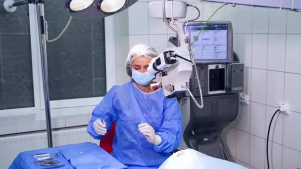 手術中の手術用顕微鏡を用いた外科医 横からのビデオ 特殊眼科に焦点を当てた選択ビデオ現代の機器や医師の仕事 — ストック動画