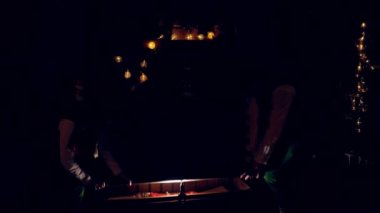 Noel 'de karanlık odada elfler. İki elf parlayan kasayı açıyor ve Noel Baba 'nın hediyeleri için sihirli kırmızı bir çanta alıyor. Yeni yıl zamanı.